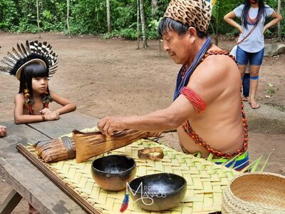 Um homem e um garoto indigéna preparando uma comida